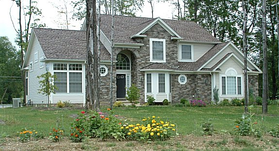 Large great room with cathedral ceiling and double sided fireplace. 2 story foyer. 1st floor master suite with 9' ceiling and optional fireplace. Loft overlooking 2 story dinette. Vaulted 1st floor parlor/den with French doors and transoms. Tray ceiling in bayed formal dining room. Optional skylights. Covered front porch. 1st floor laundry. 2-car side entry garage.